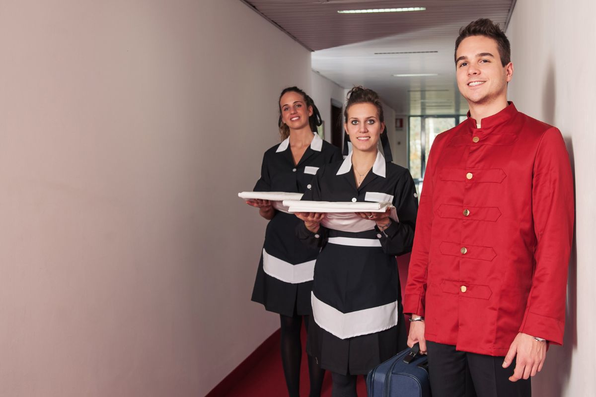 Personnel d'hôtel souriant, illustrant la chaîne de valeur dans le service clientèle d'un hôtel.