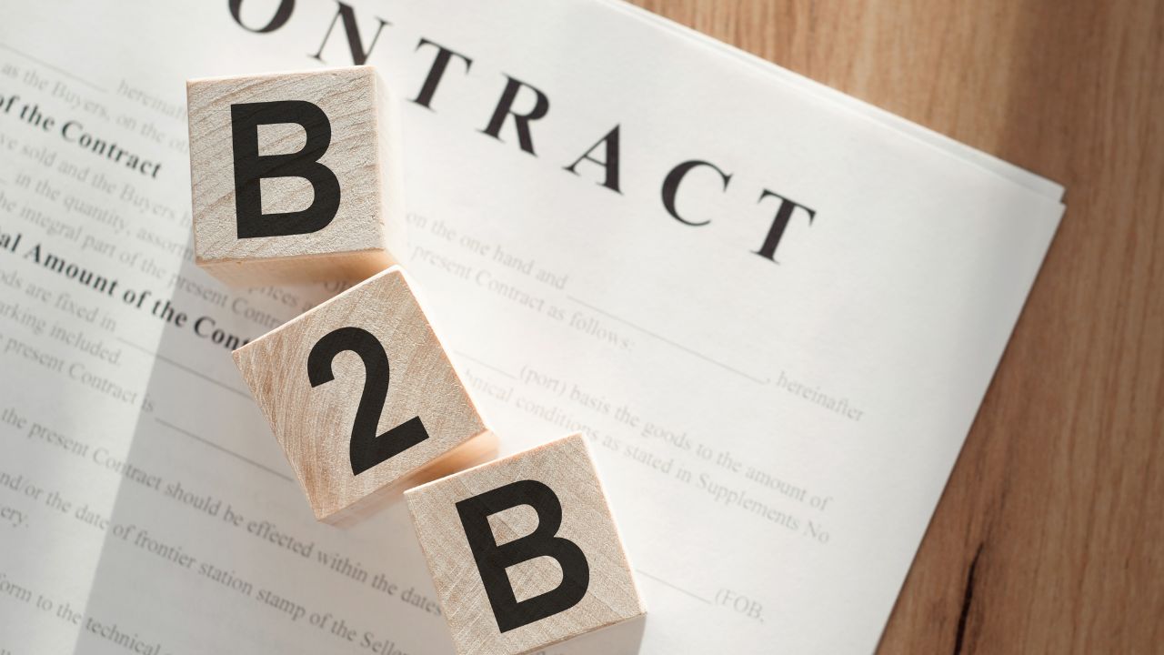 Trois cubes en bois avec les lettres B et le chiffre 2 sur un contrat intitulé B2B.